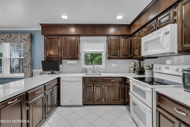 kitchen featuring dark brown cabinets, tasteful backsplash, sink, white appliances, and light tile patterned floors