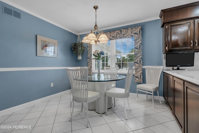 tiled dining space with ornamental molding and a chandelier