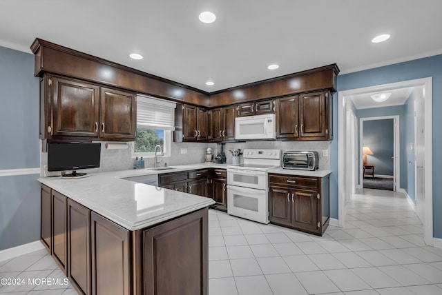 kitchen with white appliances, kitchen peninsula, dark brown cabinetry, and sink