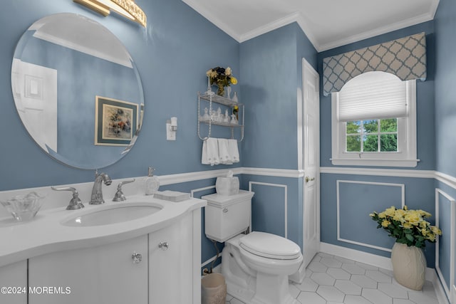 bathroom featuring tile patterned flooring, crown molding, vanity, and toilet