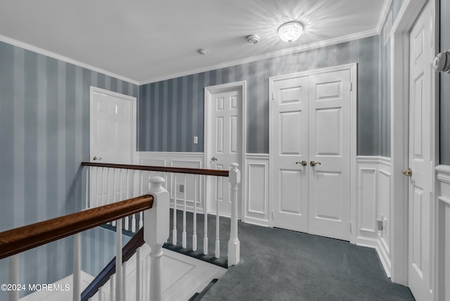 hallway featuring crown molding and dark colored carpet