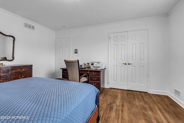 bedroom with crown molding, dark wood-type flooring, and a closet