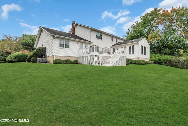 back of property with a lawn, a deck, and central air condition unit