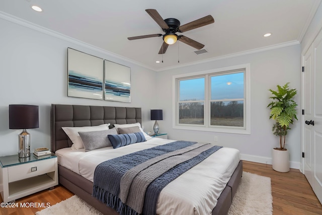 bedroom with hardwood / wood-style flooring, ceiling fan, and ornamental molding