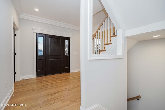 foyer with light hardwood / wood-style flooring and crown molding