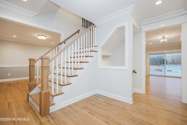 stairs featuring wood-type flooring, crown molding, and an inviting chandelier