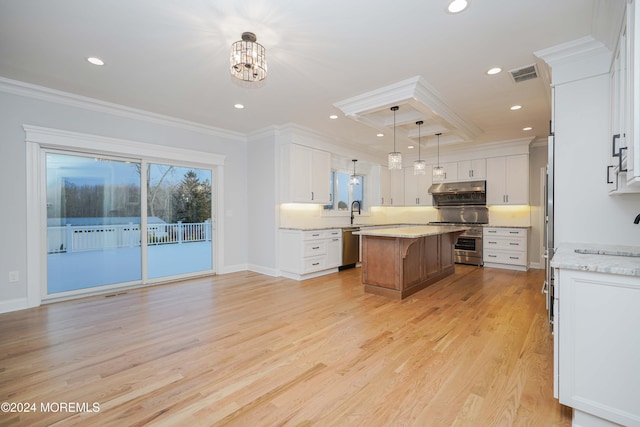 kitchen with light stone countertops, stainless steel appliances, a kitchen island, decorative light fixtures, and white cabinets