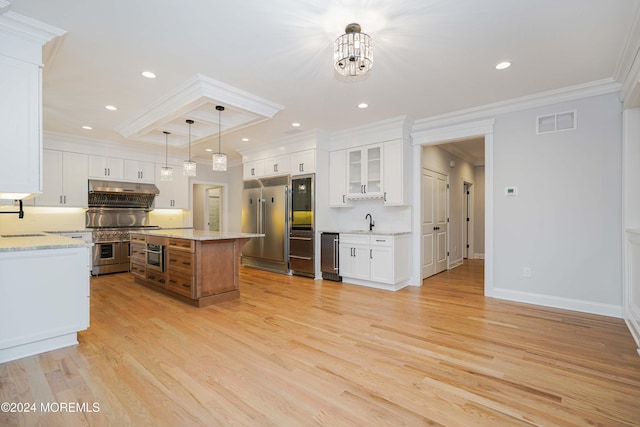 kitchen featuring white cabinets, a center island, pendant lighting, and light stone counters