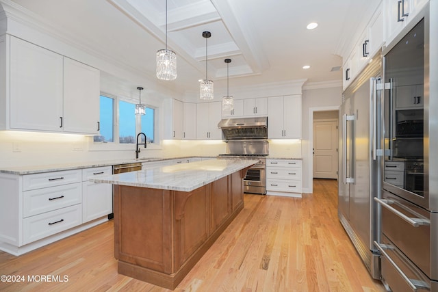 kitchen with a kitchen island, high end appliances, white cabinetry, and light wood-type flooring