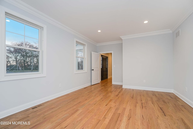 spare room with light wood-type flooring and crown molding