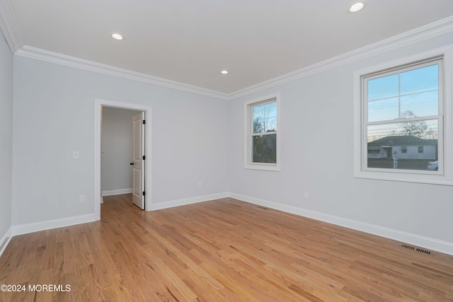 empty room featuring crown molding and light hardwood / wood-style flooring