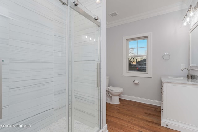 bathroom with hardwood / wood-style flooring, vanity, toilet, and ornamental molding