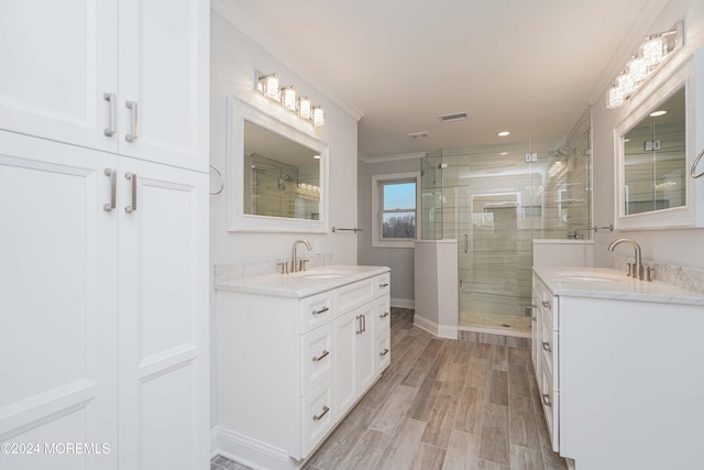 bathroom with vanity, hardwood / wood-style flooring, a shower with door, and ornamental molding