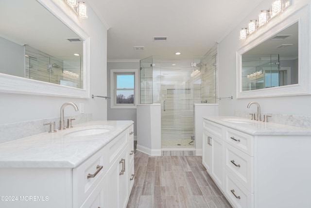 bathroom featuring hardwood / wood-style floors, vanity, walk in shower, and ornamental molding