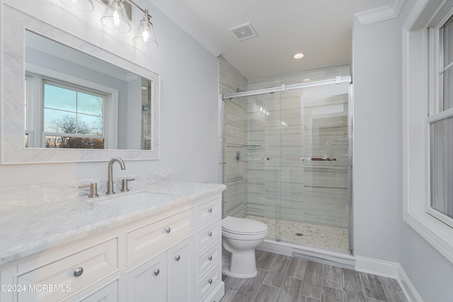 bathroom with walk in shower, crown molding, vanity, and toilet