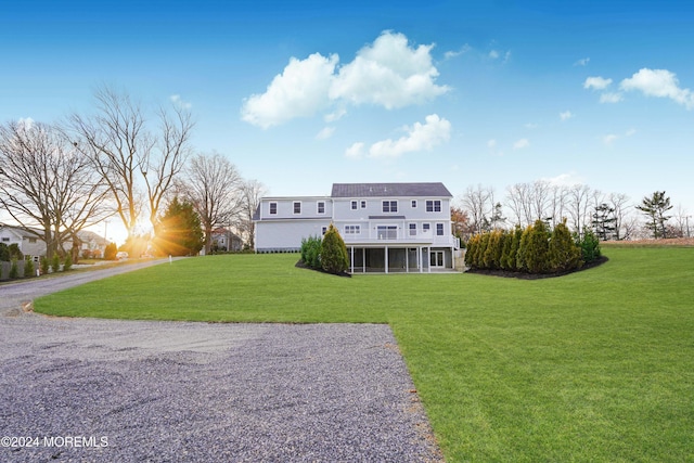 view of front facade with a sunroom and a front yard