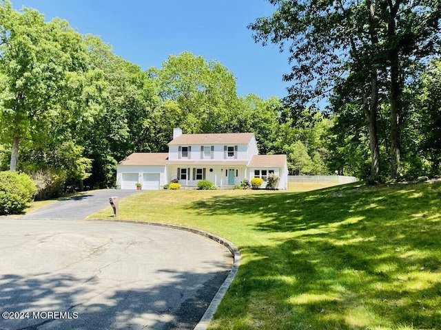 colonial home with a front yard and a garage