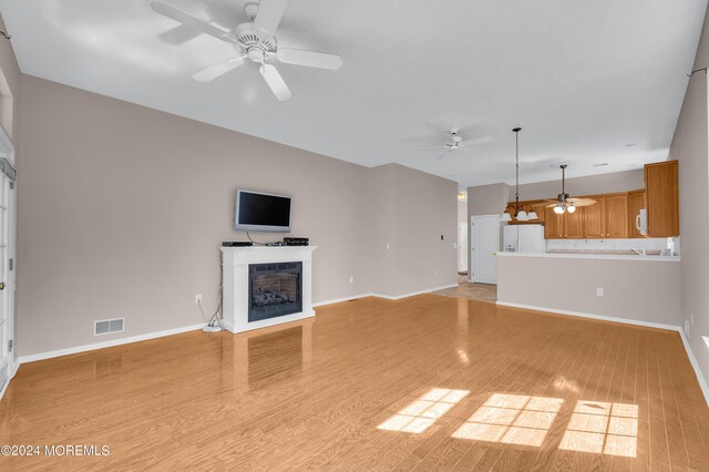 unfurnished living room with light hardwood / wood-style floors and ceiling fan