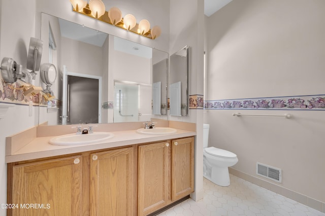 bathroom featuring vanity, toilet, an enclosed shower, and tile patterned floors