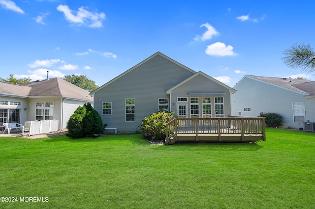 rear view of property featuring a wooden deck, central AC unit, and a lawn