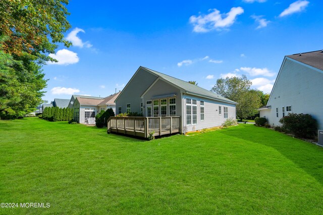 back of house with a lawn and a wooden deck