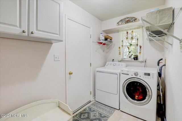 laundry area with light tile patterned floors, cabinets, and washer and dryer