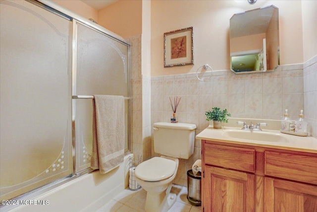 full bathroom with enclosed tub / shower combo, vanity, toilet, tile walls, and tile patterned flooring