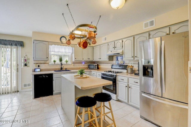 kitchen with appliances with stainless steel finishes, decorative backsplash, a center island, and sink