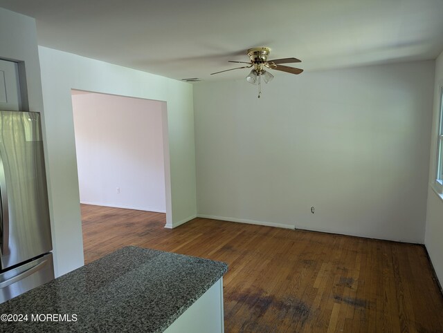 empty room featuring ceiling fan and dark wood-type flooring