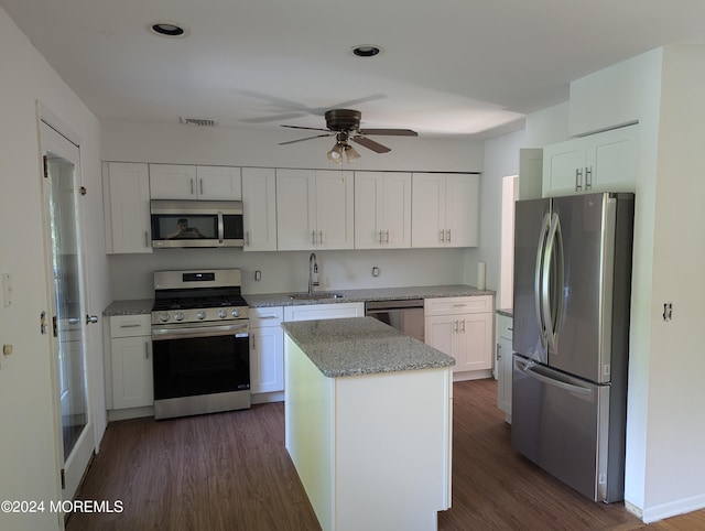 kitchen with appliances with stainless steel finishes, dark hardwood / wood-style flooring, white cabinetry, and sink