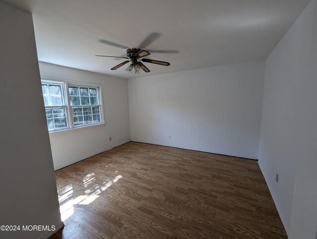 spare room with ceiling fan and dark wood-type flooring