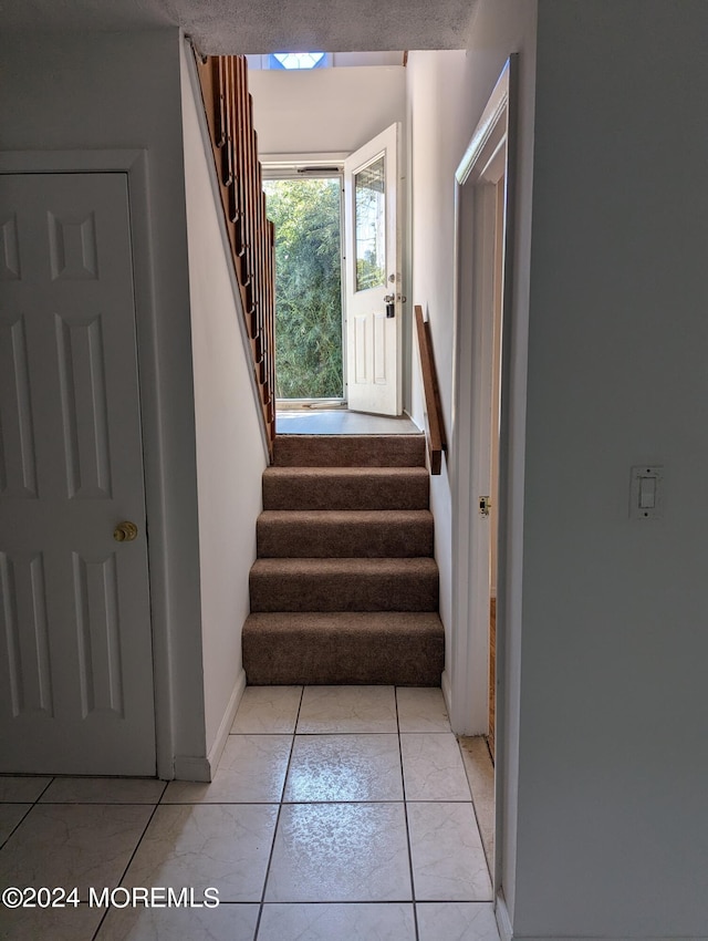 staircase with a textured ceiling