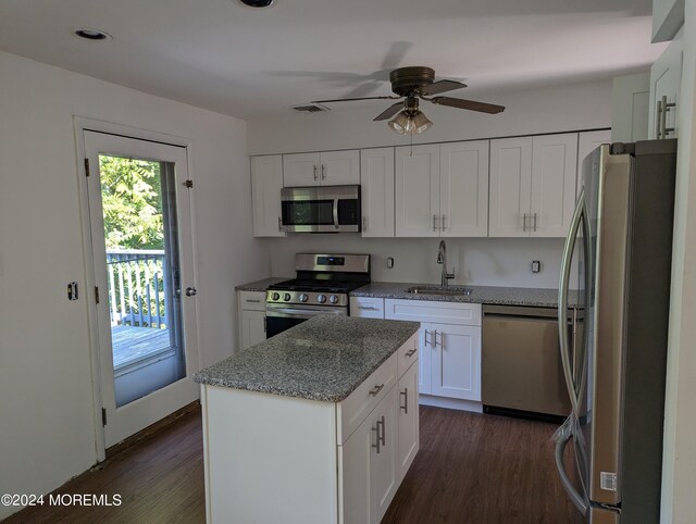 kitchen featuring white cabinets, sink, dark hardwood / wood-style floors, light stone counters, and stainless steel appliances