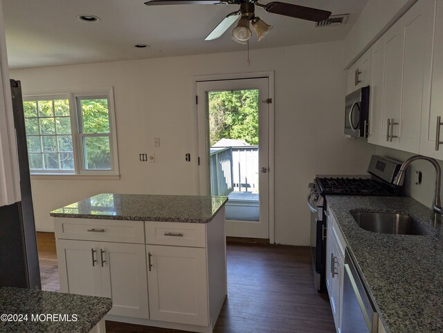 kitchen featuring a healthy amount of sunlight, dark hardwood / wood-style flooring, white cabinetry, and appliances with stainless steel finishes