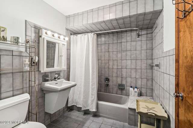 bathroom featuring shower / bath combo with shower curtain, toilet, tile walls, and tile patterned flooring