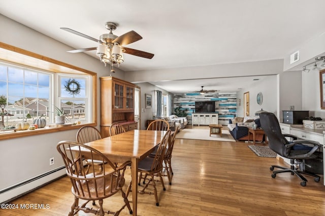 dining area with baseboard heating, light wood-type flooring, and ceiling fan