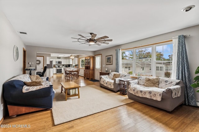 living room featuring light hardwood / wood-style flooring and ceiling fan