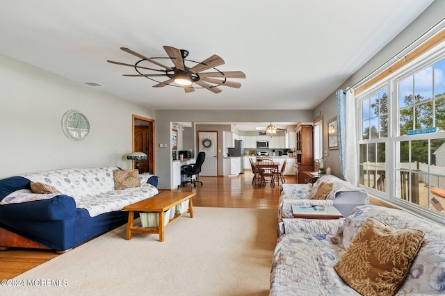 living room with light hardwood / wood-style flooring and ceiling fan