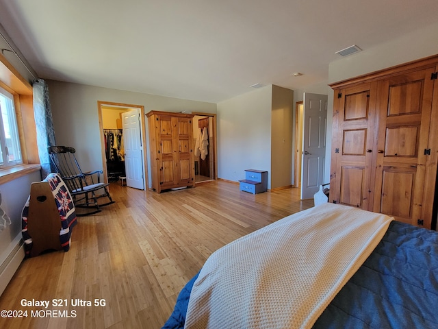 bedroom with light hardwood / wood-style flooring, a walk in closet, and a closet