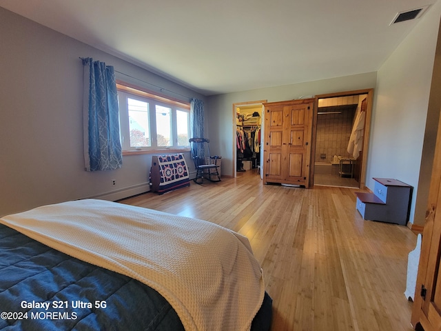 bedroom with a spacious closet, hardwood / wood-style flooring, and a closet