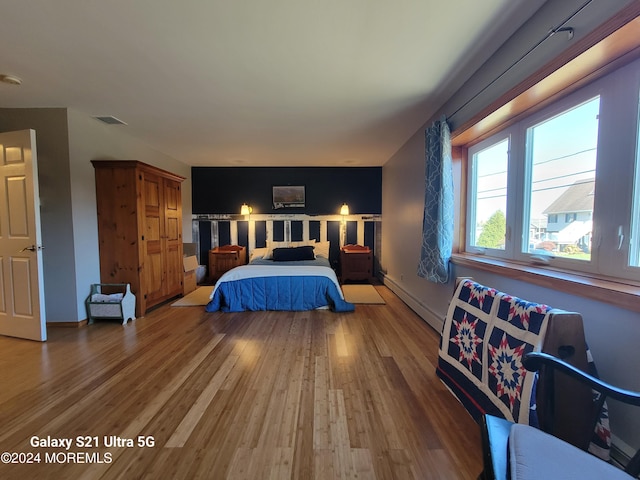 bedroom featuring a baseboard radiator and hardwood / wood-style floors