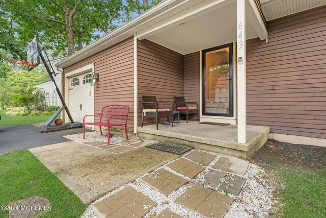 view of patio / terrace with a garage and covered porch