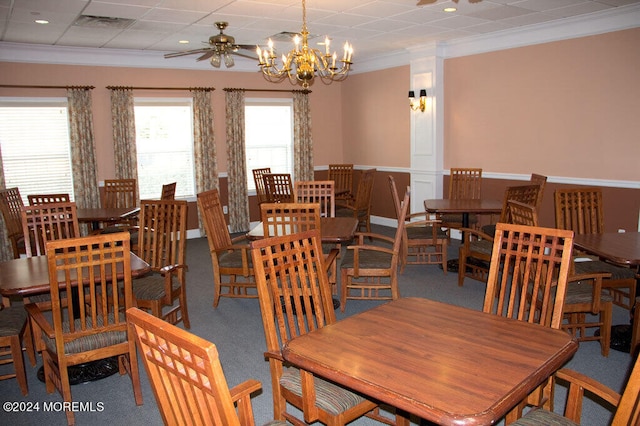 dining area with carpet flooring, crown molding, and ceiling fan with notable chandelier