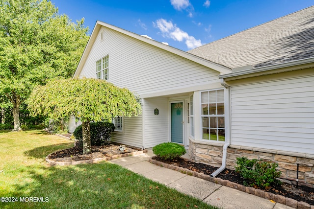 doorway to property with a lawn