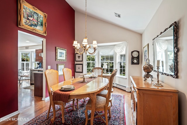 dining area featuring plenty of natural light, light hardwood / wood-style floors, baseboard heating, and a chandelier