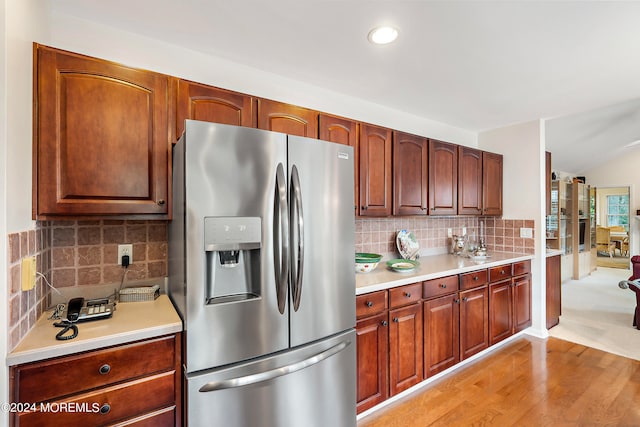 kitchen with decorative backsplash, stainless steel fridge with ice dispenser, and light wood-type flooring