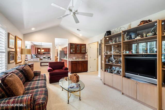 living room featuring light colored carpet, vaulted ceiling, and ceiling fan