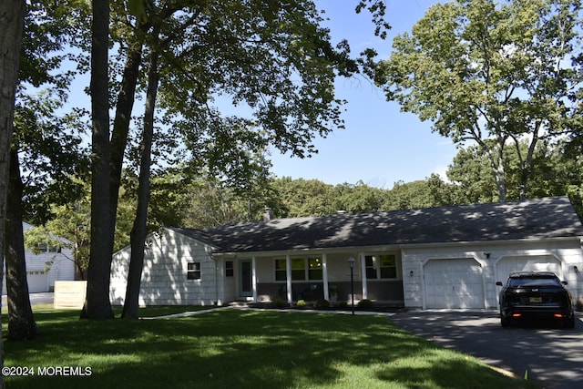 ranch-style home featuring a front lawn and a garage