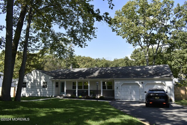 ranch-style house featuring a garage and a front yard