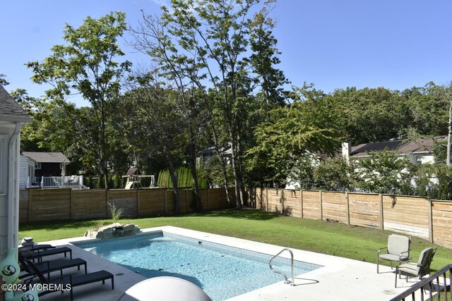 view of pool featuring a lawn and a patio area